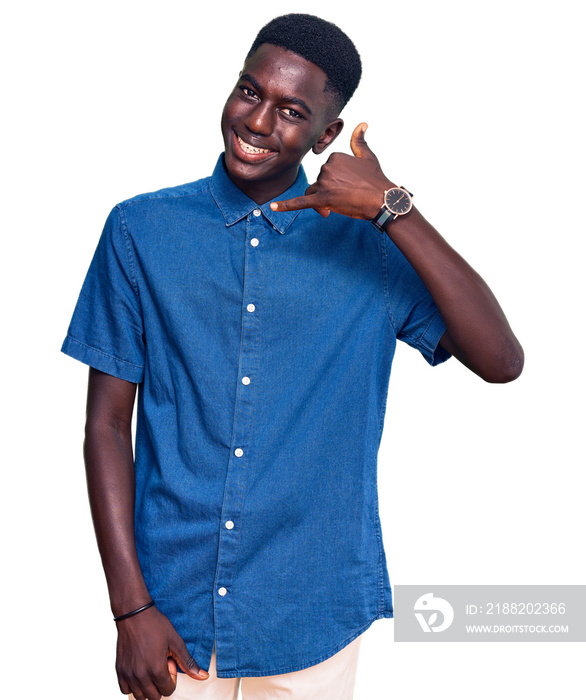 Young african american man wearing casual clothes smiling doing phone gesture with hand and fingers like talking on the telephone. communicating concepts.