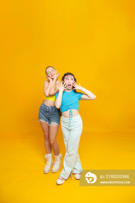 Studio portrait of smiling stylish friends making faces