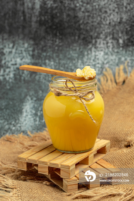 ghee oil. Ghee or clarified butter in jar on a wooden background. banner, menu, recipe place for text