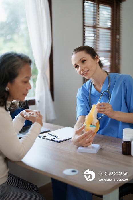 Portrait of a female doctor talking to an elderly patient about osteoarthritis.