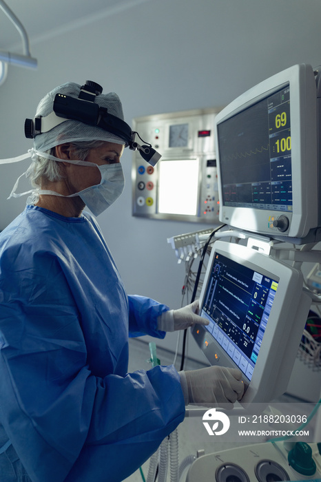 Female surgeon using the medical monitor in operation theater at hospital