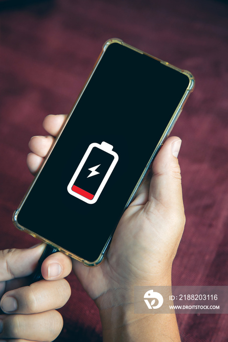 Close up a man hands plugging a charger on a smart phone on a table