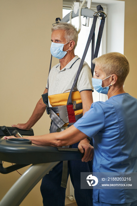 Professional physiotherapist working with patient in rehabilitation center