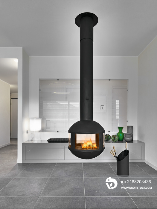 modern living room interior in the foreground the black iron fireplace suspended from to ceiling