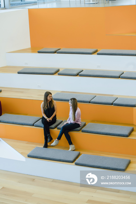 Women talking in auditorium in modern office space