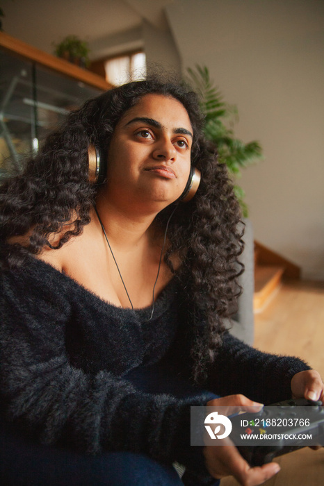 Young Indian woman with curves and Cerebral Palsy playing video games at home