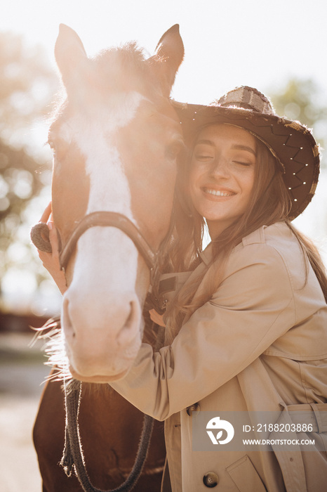 Young happy woman with horse at ranch