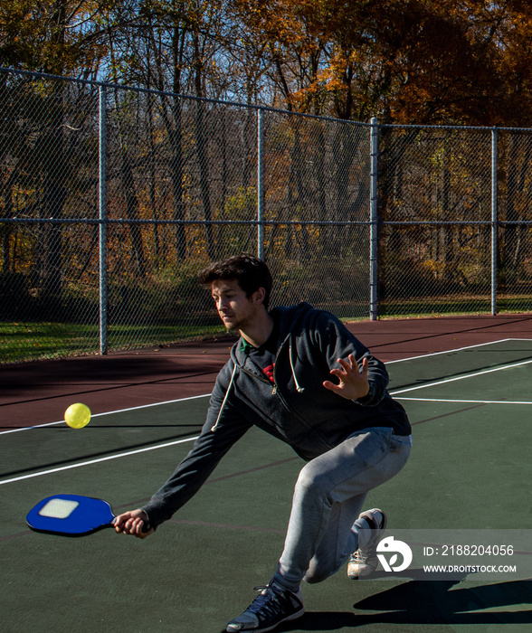 Young man playing pickleball paddle sport