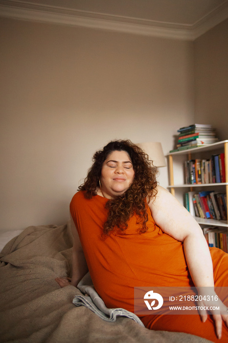 Plus-sized Sri Lankan woman with vitiligos sitting on her bed