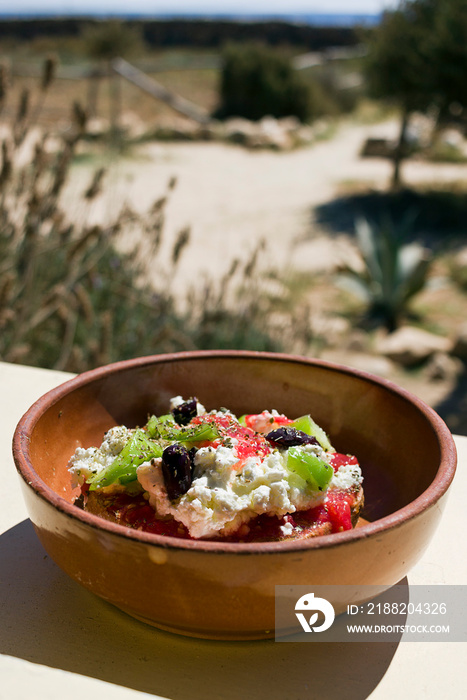 Dakos greek appetizer, dried bread, tomatoes, feta, or mizithra cheese, capers, oregano. Taken in Donoussa Island, Greece