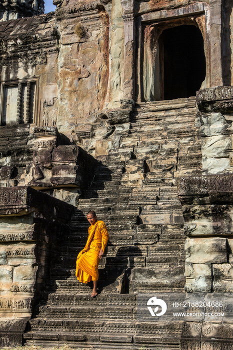 Young Buddhist monk walking down steps at temple in Angkor Wat, Siem Reap, Cambodia