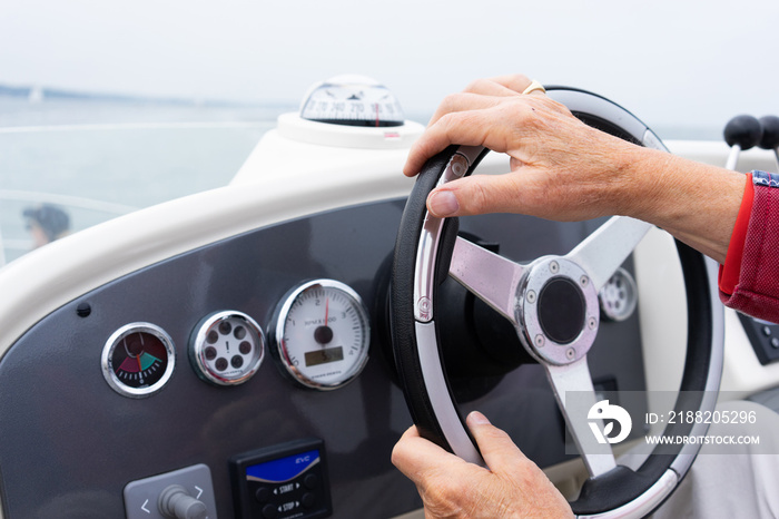 hand steering a motor cruiser on the sea