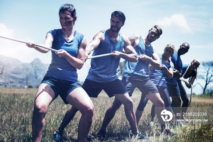 People playing tug of war during obstacle training course