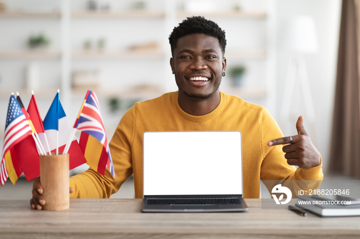 Happy black guy showing language school on laptop, mockup