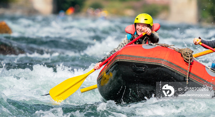 Water sport portrait of smiling happy girl in river raft. Extreme sports and happiness concept.