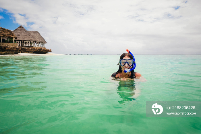 Happy woman wearing mask for snorkeling in the turquoise ocean