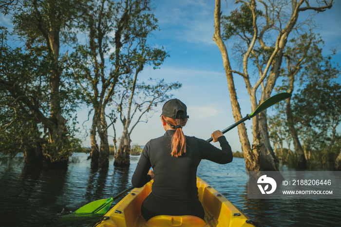 woman sailing sea kayak in mangrove forest