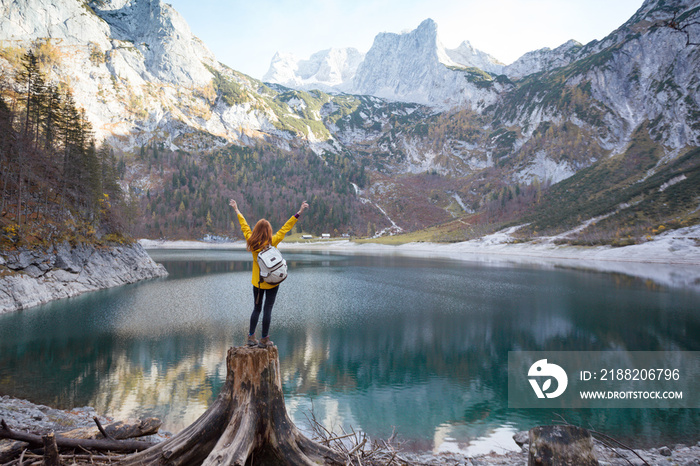 girl stands on the shore of a mountain lake