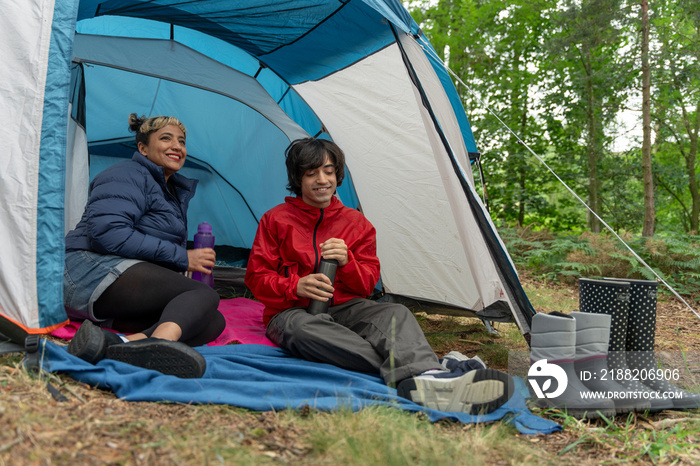 Mother and son camping in forest