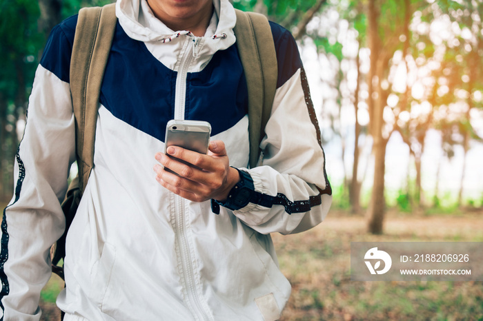 Front portrait of a young man traveler He is using mobile phone