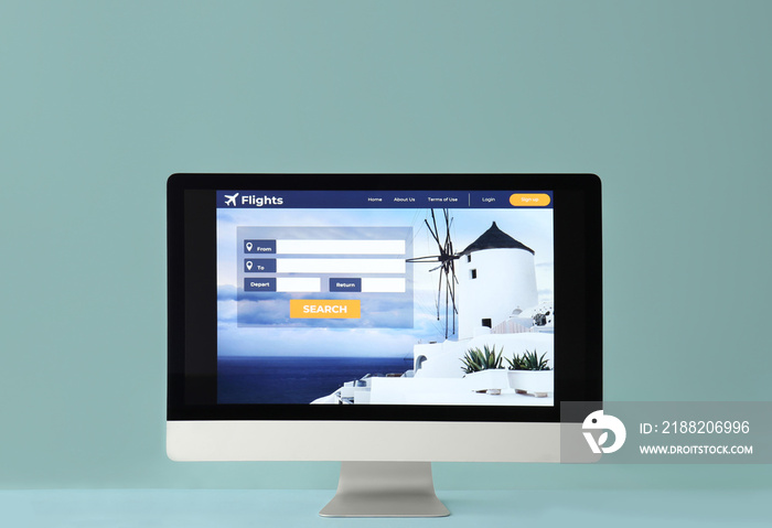 Open page of online booking service on screen of monitor against color background