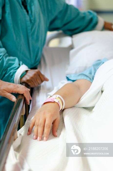 A patient lying in a hospital bed with doctors and nurses attending to her