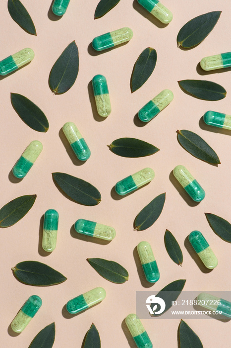 top view of phytotherapy pills with green leaves pattern on beige surface