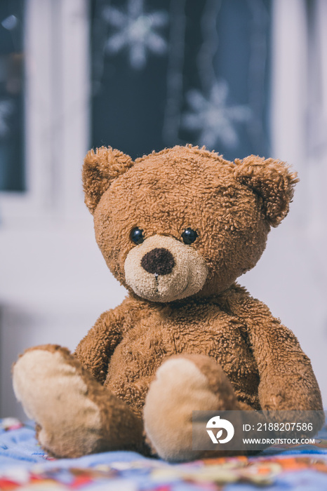 Cute teddy bear sitting on the bed