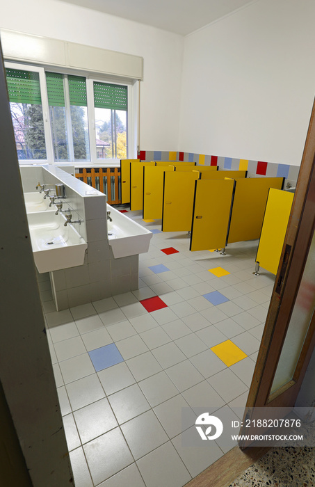 inside a school bathroom  without children and with white sinks