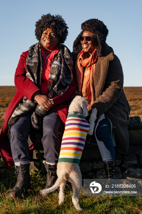 Portrait of two senior women with dog in moorland