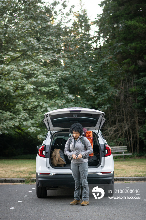 U.S. Army female soldier putting on combat boots and backpack before a hike.