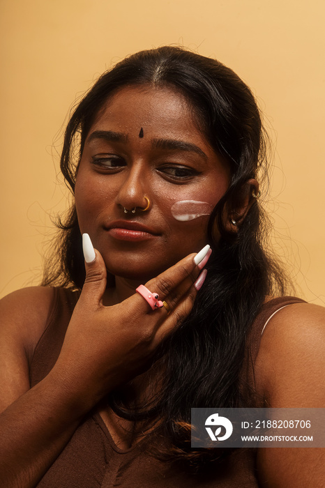 South Asian female solo lifestyle studio portrait skin care shot