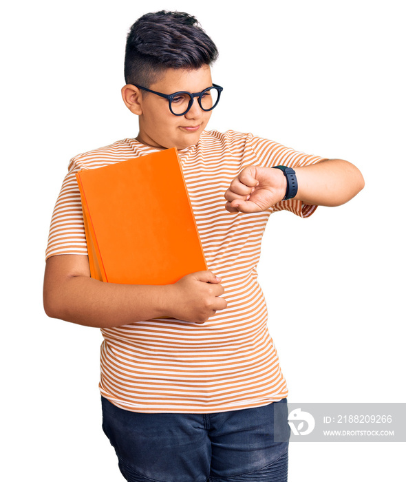 Little boy kid holding book wearing glasses checking the time on wrist watch, relaxed and confident