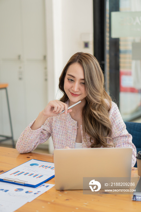 businesswoman or accountant Asian girl working on laptop Financial investment trading concept with a calculator. Calculate. Analyze business and market growth on an accounting data graph. Economy