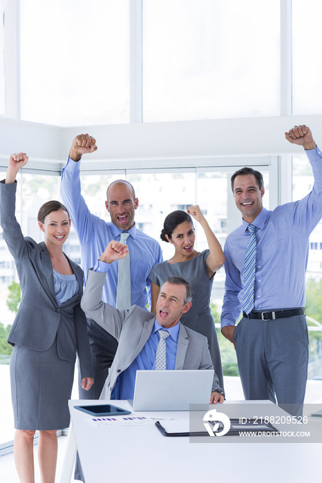 Smiling business team celebrating and looking at camera