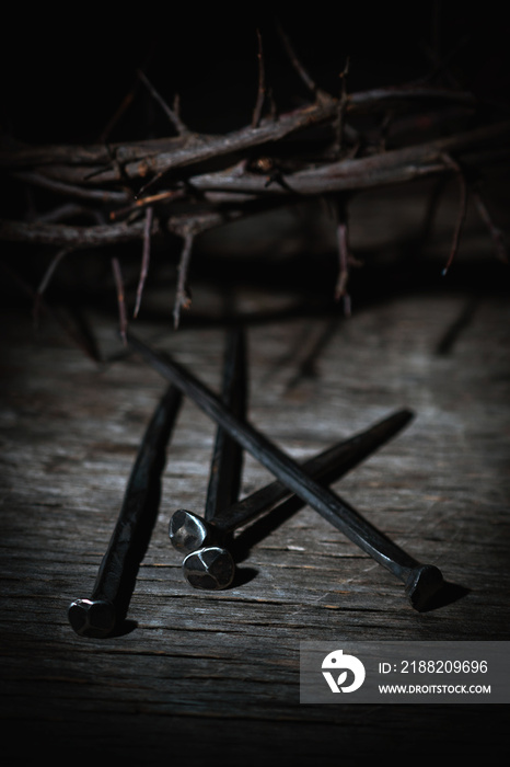 Crown thorns and nails as symbol of passion, death and resurrection of Jesus Christ. Selective focus on metal nails.