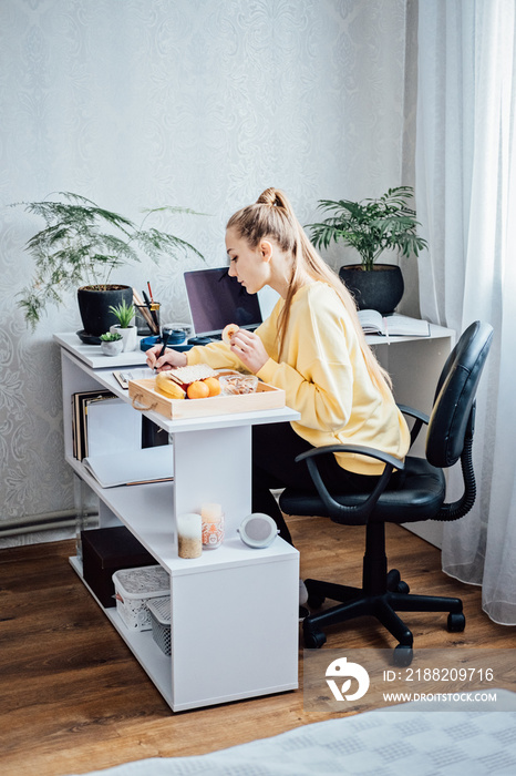 Flexible working, flexible work. Young woman freelancer working at home office with laptop and documents. Flexible work schedule.