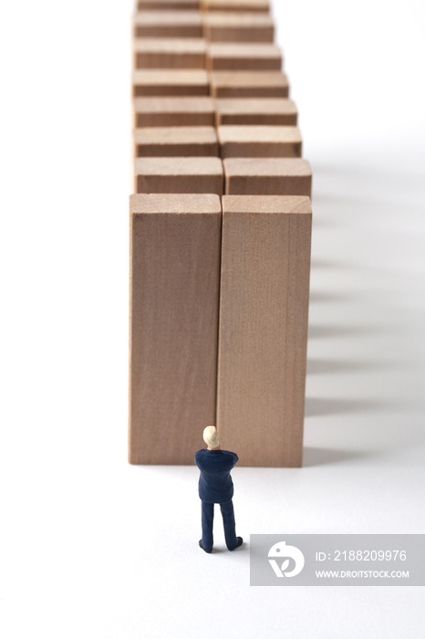 Miniature businessman with multiple obstacle walls