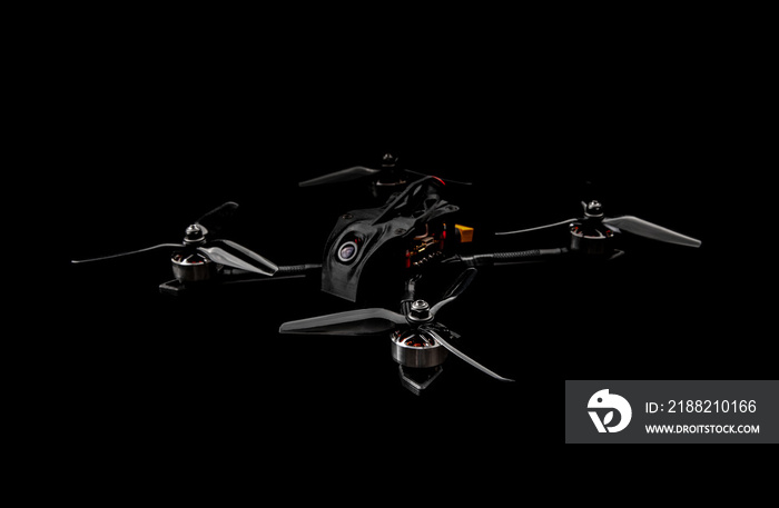 Modern FPV drone on a black background. Four-engine aircraft on the radio control. Drone for racing, filming and entertainment.