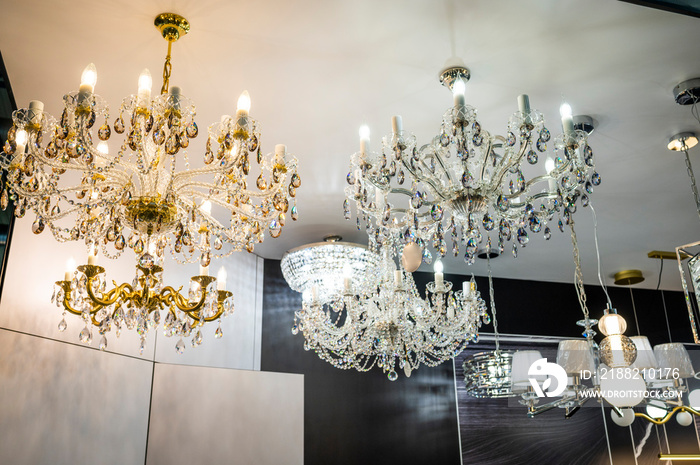 Luminous crystal chandeliers on the ceiling in a shop window