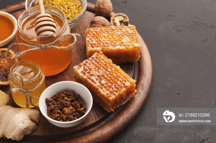 Various types of honey on wooden platter, closeup