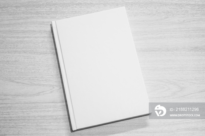 Real 3D hardcover white book on a wood background