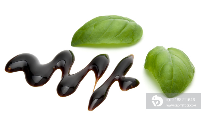 Balsamic vinegar cream and basil leaves isolated on white background. Italian salad dressing, sauce.