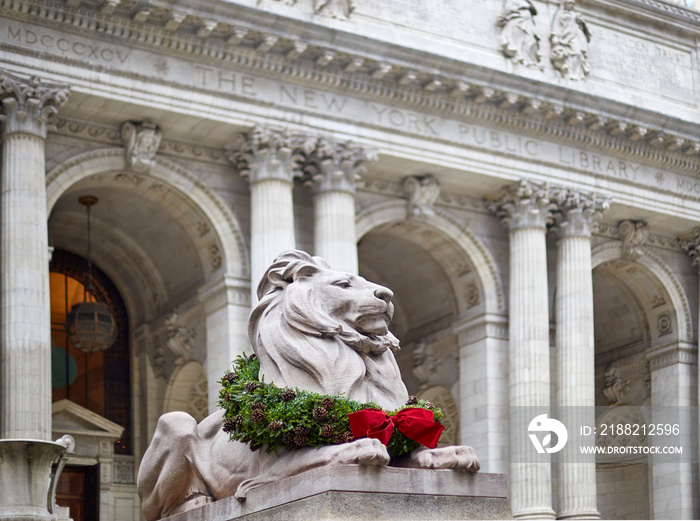 statue of the lion in the new york library decorated for christmas