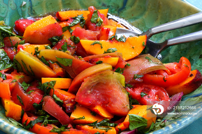 Bowl of fresh peach, tomato and basil salad