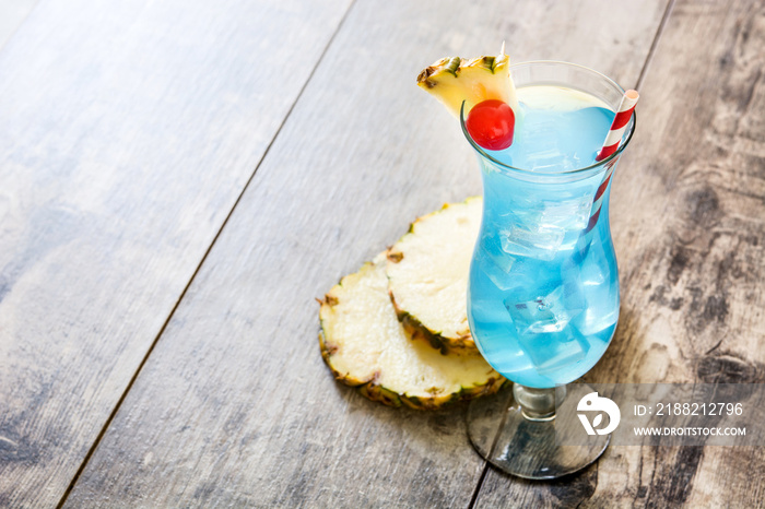 Blue Hawaiian cocktail on wooden table. Copyspace