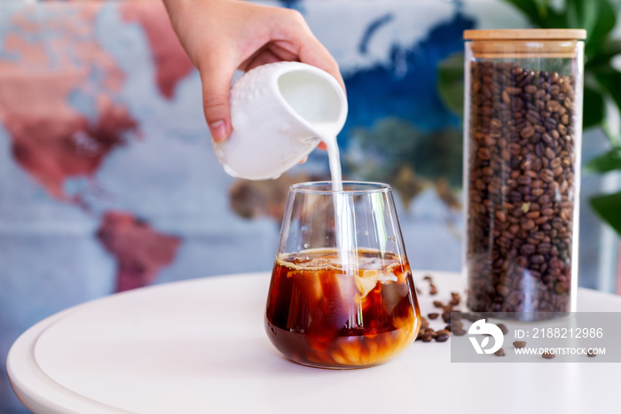 a glass of cold brew coffee with milk on white table