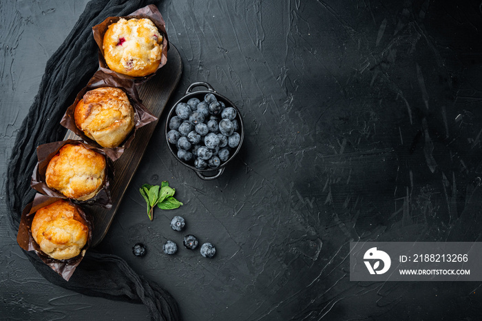 Homemade blueberries muffins, on black background, top view flat lay with copy space for text