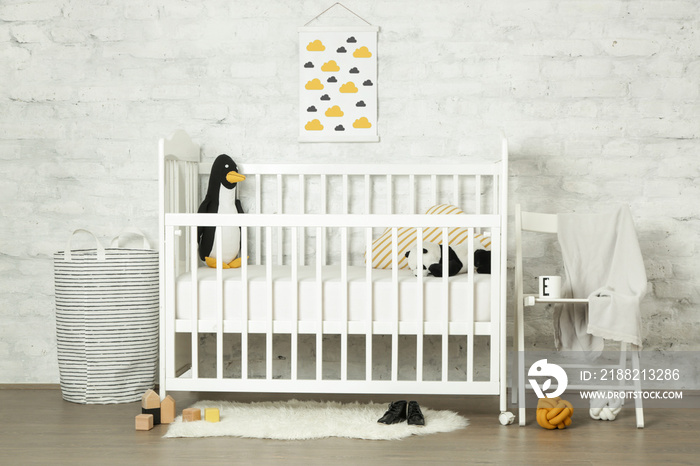 White wooden baby crib and toys in the room, Scandinavian inspired kids room interior