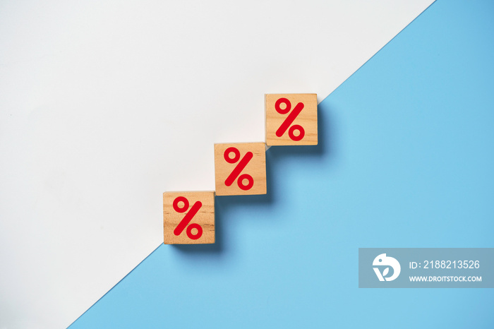 Red percentage sign print screen on wooden cube block on white and blue background for increase financial interest rate and business investment growth from dividend concept.